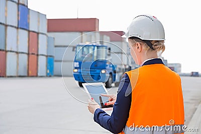 Rear view of female engineer using tablet PC in shipping yard Stock Photo