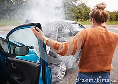 Rear View Of Female Motorist With Head Injury Getting Out Of Car After Crash Stock Photo