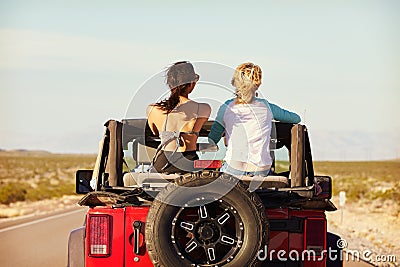 Rear View Of Friends On Road Trip Driving In Convertible Car Stock Photo