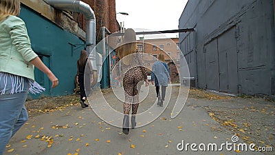 Rear view of girls in trendy, fashionable clothes walking on the street back view. Girls friends walk . Girl walking the Editorial Stock Photo