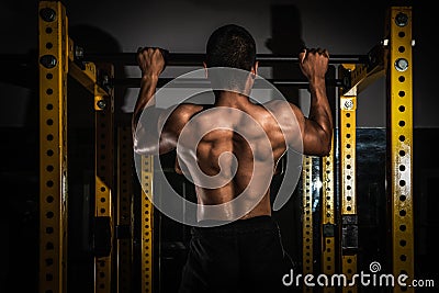 Rear view of healthy muscular young man with his arms stretched out, Strong athletic man fitness model torso showing six pack abs, Stock Photo