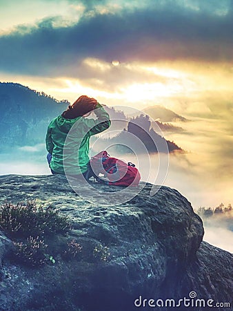 Rear view of hiker woman on top of mountain peak in rocks Stock Photo