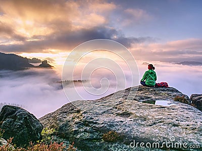 Rear view of hiker woman on top of mountain peak in rocks Stock Photo