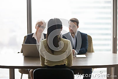 Rear view of job applicant talks to recruiters at interview Stock Photo