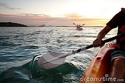 Rear view of kayaker man paddle kayak at sunset sea. Kayaking, canoeing, paddling Stock Photo