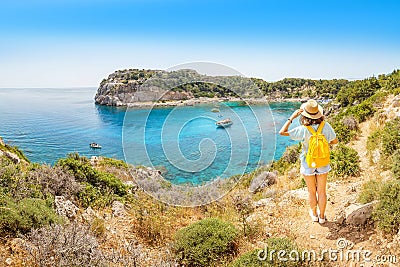 View of a lonely girl with a yellow backpack admiring a beautiful azure Bay in a tropical resort Stock Photo