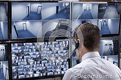 Operator Looking At Multiple Camera Footage On Computer Stock Photo