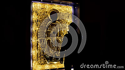 Rear view of a man coming close to the sacred golden icon under the protective glass. Concept. Interior of the orthodox Stock Photo