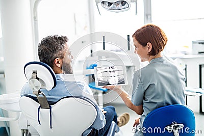 Rear view of man and dentist in dental surgery, annual check-up. Stock Photo
