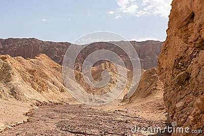 Rear view of man hiking in golden Canyon with scenic view of colorful geology of multi hued Amargosa Chaos rock formations Stock Photo
