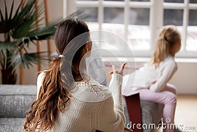 Rear view at mother scolding daughter, child rebuke and punishme Stock Photo