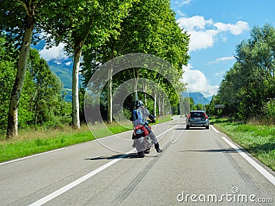 Rear view of motorcyclist overtake a gray Swedish Volvo V 60 car driving on Editorial Stock Photo