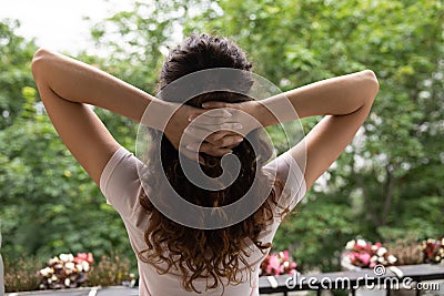 Rear view peaceful young woman stretching, standing on balcony Stock Photo