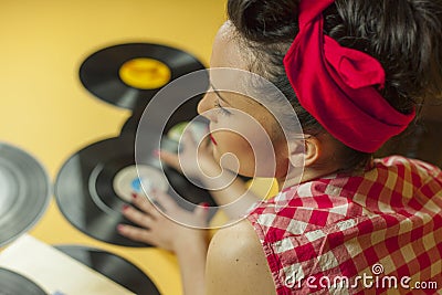 Rear view portrait pin up girl with old vinil records. Selective Stock Photo