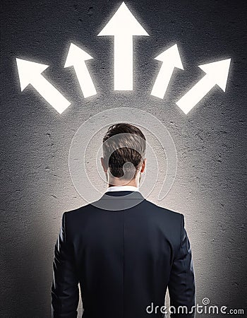 Rear view puzzled businessman facing a wall with multiple illuminated arrows pointing up. Decision-making or choosing the relevant Stock Photo