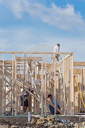 Rear view roofer builder worker on wooden roof trusses construct Stock Photo