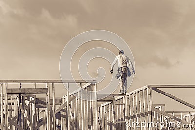 Rear view roofer builder worker on wooden roof trusses construct Stock Photo