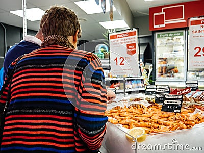 Rear view senior woman buying shrimps supermarket Editorial Stock Photo