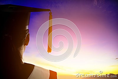 Rear view silhouette of Student Graduation watching the sunrise Stock Photo