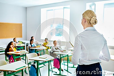 rear view of teacher looking at children Stock Photo