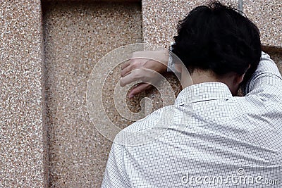 Rear view of tired and worried young Asian man in depression crying Stock Photo