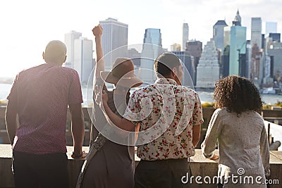 Rear View Of Tourists Looking At Manhattan Skyline Stock Photo