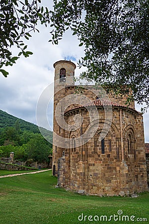 Rear view with tree of the Collegiate Church of San Martin de Elines of the twelfth century Stock Photo