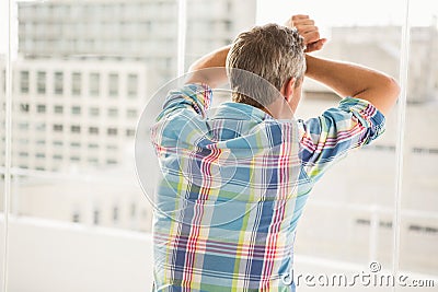 Rear view of troubled casual businessman leaning against window Stock Photo