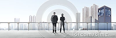 Rear view of two asian business people standing on modern terrace and looking at view Stock Photo