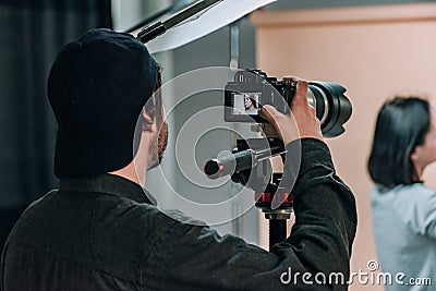 Rear view of videographer with assistant and model working Stock Photo