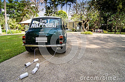 Rear view of a vintage car with just married sign and cans attached and beautiful landscape Editorial Stock Photo