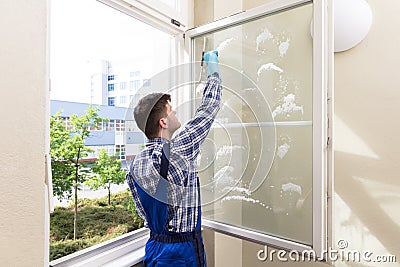 Housekeeper Cleaning Window Stock Photo