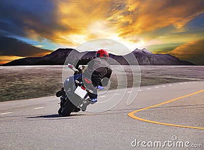Rear view of young man riding motorcycle in asphalt road curve w Stock Photo