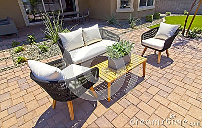 Rear Yard Patio With Wicker Sofa And Chairs On Pavers Stock Photo