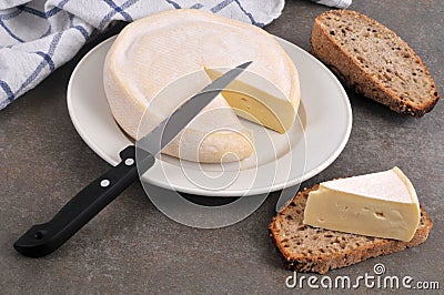 French Reblochon cheese on a plate with a knife Stock Photo