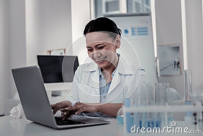 Smiling satisfied scientist analysing experiments results in the lab Stock Photo