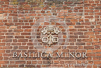 The Basilica Minor sign on the red bricks wall at the entrance to the church Editorial Stock Photo