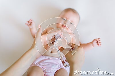 Recently cleaned baby ready for oil. Mother with bottle in hand Stock Photo