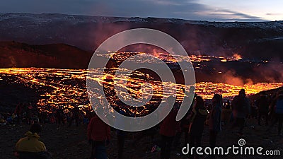 Recently started volcanic eruption at Fagradalsfjall with glowing streams of lava and the silhouettes of people. Editorial Stock Photo