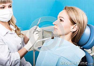 The reception was at the female dentist. Doctor examines the oral cavity on tooth decay. Caries protection. doctor puts Stock Photo