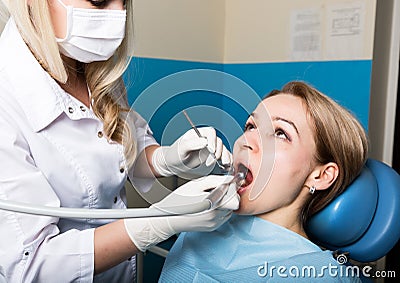 The reception was at the female dentist. Doctor examines the oral cavity on tooth decay. Caries protection. doctor puts Stock Photo