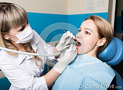 The reception was at the female dentist. Doctor examines the oral cavity on tooth decay. Caries protection. doctor puts Stock Photo