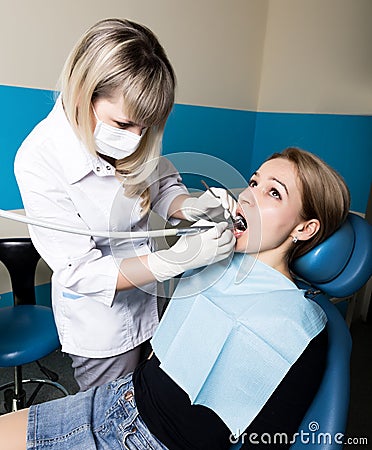 The reception was at the female dentist. Doctor examines the oral cavity on tooth decay. Caries protection. doctor puts Stock Photo