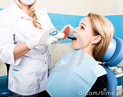 The reception was at the female dentist. Doctor examines the oral cavity on tooth decay. Caries protection. Tooth decay Stock Photo