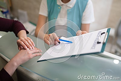 Receptionist of dentistry showing the form to fill in and sign Stock Photo