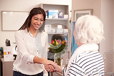 Receptionist Greeting Female Patient At Hearing Clinic Stock Photo