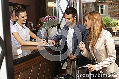 Receptionist and guests at hotel Stock Photo