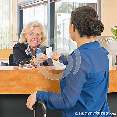 Receptionist helping a newly arriving hotel guest Stock Photo