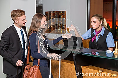 receptionist at hotel reception handing over key to guest or customer Stock Photo