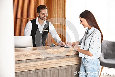 Receptionist registering client at desk Stock Photo